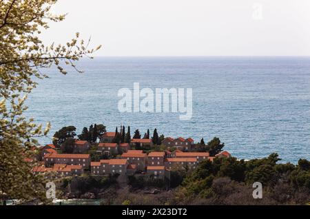 Île de Sveti Stefan dans la mer Adriatique, Monténégro. Île avec maisons et arbres. Voyez à travers les arbres d'en haut. Balkans. Arrière-plan Banque D'Images