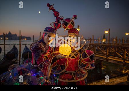 Carnaval de Venise : magnifiques masques d'arlequin devant le Grand canal la nuit, Venise, Italie Banque D'Images