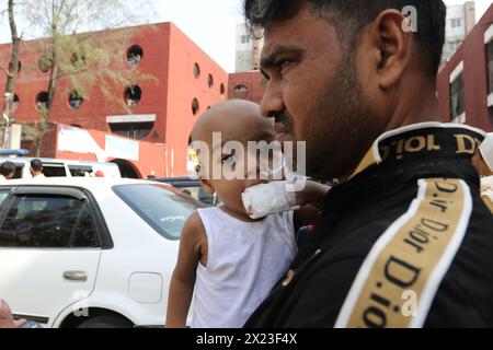 Dhaka, Bangladesh. 18 avril 2024. Un homme portant son bébé est vu après avoir évacué l'hôpital pour enfants du Bangladesh, après un incendie causé par un climatiseur dans l'unité de soins intensifs cardiaques. (Crédit image : © S A Masum/eyepix via ZUMA Press Wire) USAGE ÉDITORIAL SEULEMENT! Non destiné à UN USAGE commercial ! Banque D'Images