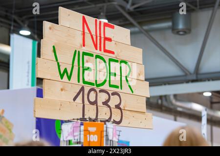 Auf einem Schild an einem Messesestand ist der Schriftzug nie wieder 1933 AM 22.03.2024 in einer der Messehallen der Leipziger Buchmesse zu lesen. AM 30. Januar 1933 uebertrug Reichspraesident von Hindenburg die Macht im Deutschen Reich auf Adolf Hitler. Mehr als 2000 Ausstellerinnen und Aussteller aus 40 Laendern nehmenan der Leipziger Buchmesse teil. Nach der Frankfurter Buchmesse ist die Leipziger Buchmesse derzeit die zweitgroesste Deutschlands. Les mots Never Again 1933 peuvent être lus sur une pancarte sur un stand de foire le 22 mars 2024 dans l'un des halls d'exposition de la Foire du livre de Leipzig. Banque D'Images