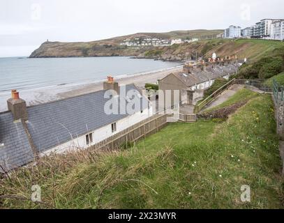 Une rangée de chalets à Port Erin, île de Man, où les petits jardins mènent directement à la plage elle-même. Banque D'Images