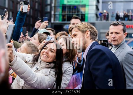 Berlin, Allemagne. 19 avril 2024. Ryan Gosling, acteur, se fait photographier avec des fans à son arrivée au cinéma UCI luxe East Side Gallery pour la première européenne du film « The Fall Guy ». Crédit : Christoph Soeder/dpa/Alamy Live News Banque D'Images