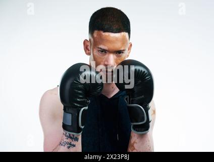 Homme sérieux, portrait et boxeur avec des gants pour le combat, tournoi ou match de boxe sur un fond blanc de studio. Homme personne, vitiligo ou combattant prêt Banque D'Images