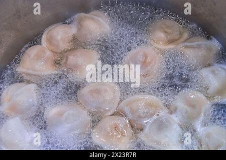 Les boulettes sont bouillies dans l'eau. Gros plan sur une image de boulettes d'eau bouillante. Banque D'Images