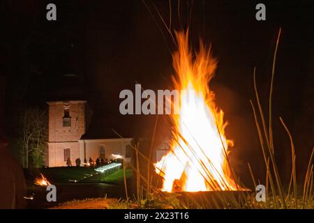 Holz brennt in einer Feuerschale vor Beginn einer meditativen Osternacht am Karsamstag, 30.03.2024, vor der Dorfkirche in Guenterberg, Uckermark, Brandebourg. Die Osternacht wurde mit Taize-Gesaengen umrahmt. Die Gesaenge Stammen aus der oekumenischen Bruderschaft von Taize und wurden entwickelt um Menschen aus der ganzen Welt anzuziehen, die sich fuer spirituel Erfahrungen und oekumenische Begegnungen interessieren. Le bois brûle dans un bol de feu avant le début d'une veillée méditative de Pâques le samedi Saint, 30 mars 2024, devant l'église du village de Guenterberg, Uckermark, Brandebourg. Banque D'Images