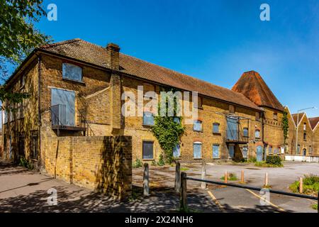 Un bâtiment industriel avec des fenêtres et des portes arborées et apparemment plus utilisé à Staines-upon-Thames, Surrey, Royaume-Uni Banque D'Images