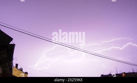 Foudre pendant un orage. De nombreux éclairs frappent les toits des maisons de la ville. Temps orageux terrible. Décharges d'électricité en th Banque D'Images