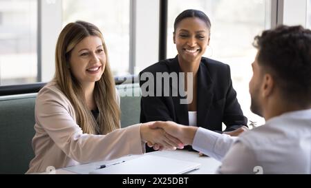 Partenaires commerciaux multiethniques satisfaits positifs se serrant la main Banque D'Images