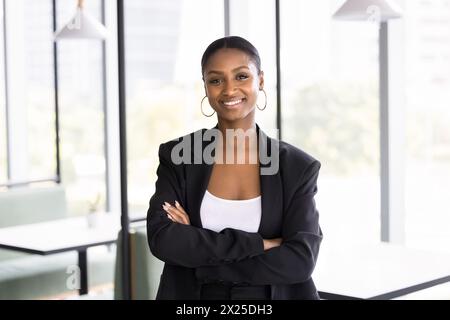 Heureuse femme de chef d'entreprise africaine attrayante regardant la caméra Banque D'Images