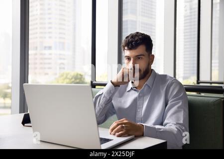 Jeune homme de gestionnaire arabe réfléchi travaillant à l'ordinateur portable Banque D'Images