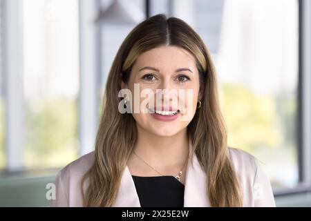 Heureuse femme exécutive d'affaires caucasienne debout à l'intérieur Banque D'Images