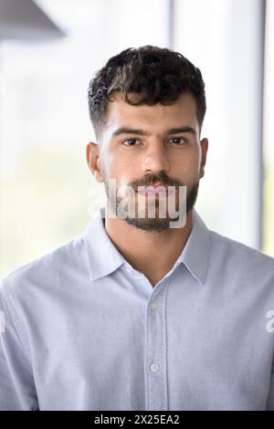 Homme d'affaires arabe sérieux en chemise formelle regardant la caméra Banque D'Images