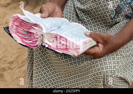 Village chrétienne vieille femme africaine, lecture religieuse holly livre biblique, habillé décontracté Banque D'Images