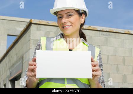 femme constructeur montrant un doigt sur une bannière vierge Banque D'Images