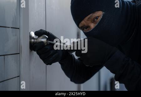 Le voleur essaie d'entrer par effraction dans la maison Banque D'Images