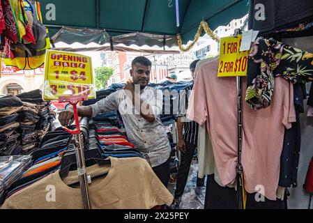 Deux hommes travaillant dans un étal de vêtements au marché Campbell Lane dans le quartier Little India de Singapour un dimanche Banque D'Images