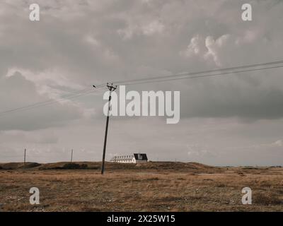 Le paysage plat éloigné avec poteau télégraphique et maisons éloignées à Dungeness Kent Angleterre Royaume-Uni Banque D'Images