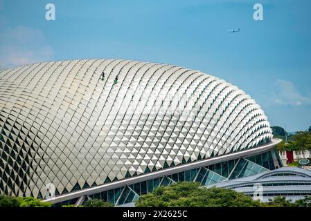 Deux hommes portant des harnais EPI travaillant sur le toit de l'un des Esplanade - théâtres sur la baie de Singapour Banque D'Images