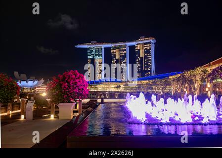 Vue sur la fontaine de Clifford Square la nuit vers l'hôtel Marina Bay Sands et le musée des sciences de l'art à Singapour Banque D'Images