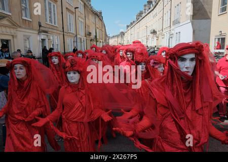 Bath, Somerset, Royaume-Uni. 20 avril 2024. Dans une puissante démonstration de solidarité pour l'environnement, des villes du monde entier, y compris Bath, Royaume-Uni, Boston, Sydney, Gothenburg et Lisbonne accueillent des processions « funérailles pour la nature ». La plus grande Assemblée de rebelles rouges, plus de 400 personnes vêtues de tenues rouges distinctives, se réunit à Bath. La procession culmine dans une finale dramatique devant l'abbaye. Organisé sous la bannière « Code Rouge pour la nature », l’événement vise à sensibiliser à la crise de la biodiversité et à inspirer une action collective urgente. Crédit : Joao Daniel Pereira/Alamy Live News Banque D'Images