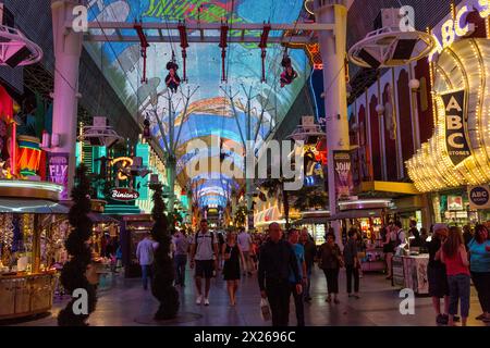 Las Vegas, Nevada. Fremont Street. Quatre coureurs sur la ligne Zip Zoomline Cowboy approche signe. Banque D'Images