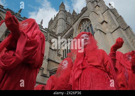 Bath, Somerset, Royaume-Uni. 20 avril 2024. Bath, Royaume-Uni. 20 avril 2024. Dans une puissante démonstration de solidarité pour l'environnement, des villes du monde entier, y compris Bath, Royaume-Uni, Boston, Sydney, Gothenburg et Lisbonne accueillent des processions « funérailles pour la nature ». La plus grande Assemblée de rebelles rouges, plus de 400 personnes vêtues de tenues rouges distinctives, se réunit à Bath. La procession culmine dans une finale dramatique devant l'abbaye. Organisé sous la bannière « Code Rouge pour la nature », l’événement vise à sensibiliser à la crise de la biodiversité et à inspirer une action collective urgente. Crédit : Joao Daniel Pereira/Alamy L. Banque D'Images