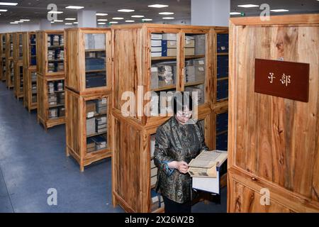 (240420) -- CHANGCHUN, 20 avril 2024 (Xinhua) -- Wang Lihua, directeur du département des livres anciens de la bibliothèque de l'université de Jilin, vérifie la préservation des livres anciens à la bibliothèque de l'université de Jilin à Changchun, dans la province de Jilin, au nord-est de la Chine, le 19 avril 2024. L'Université Jilin possède une collection de près de 400 000 livres anciens dans sa bibliothèque. Selon Zhang Qi, restaurateur de livres anciens à la bibliothèque de l'Université de Jilin, l'école effectue des travaux de restauration de livres anciens depuis les années 1950, qui n'ont jamais été interrompus depuis des décennies. Générations d'anciens Banque D'Images