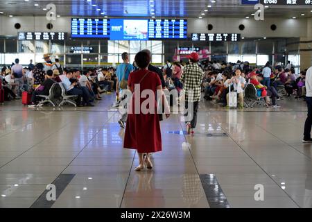 Hongqiao Railway Station, Shanghai, Chine, Asie, Une personne en vêtements rouges marche à travers une zone d'attente d'aéroport, Yichang, province du Hubei Banque D'Images