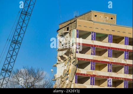 Un bâtiment de plusieurs étages est démoli sous un ciel bleu clair Banque D'Images