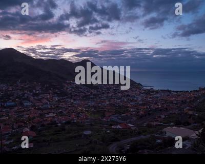 Vue panoramique de la ville Machico avant le lever du soleil dans la vallée sur la côte est de l'île de Madère, Portugal, une destination touristique populaire, sur oreille nuageuse Banque D'Images