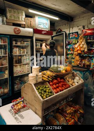 Femmes magasins pour la nourriture, les boissons et les collations dans un petit charmant marché de rue au Mexique la nuit. Banque D'Images