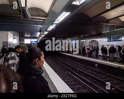 Paris, France, 19 avril 2024 : station de métro Paris Surlferino, personnes attendant sur le quai pour le métro, arrivée du train à la gare, tunnel lig Banque D'Images