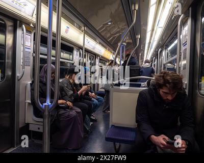 Paris, France, 19 avril 2024 : les gens, les touristes qui prennent le métro à Paris, lisent des informations sur leurs téléphones tout en voyageant à l'intérieur de la voiture, FR Banque D'Images