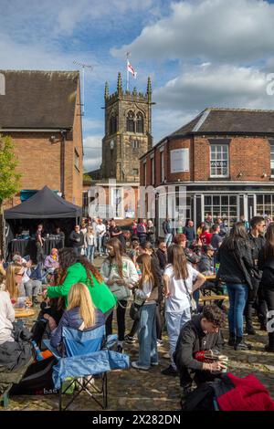 Fêtards et festivaliers appréciant le soleil de printemps sur la place du marché pavée de la ville de Sandbach dans le Cheshire au festival de musique Banque D'Images