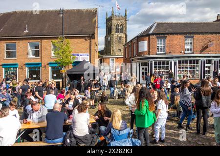 Fêtards et festivaliers appréciant le soleil de printemps sur la place du marché pavée de la ville de Sandbach dans le Cheshire au festival de musique Banque D'Images