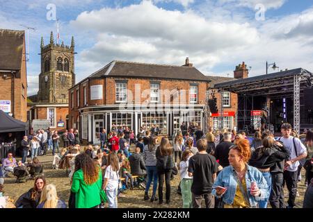 Fêtards et festivaliers appréciant le soleil de printemps sur la place du marché pavée de la ville de Sandbach dans le Cheshire au festival de musique Banque D'Images