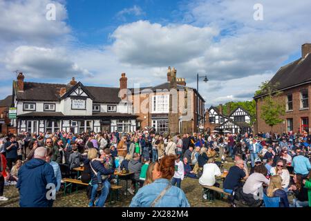 Fêtards et festivaliers appréciant le soleil de printemps sur la place du marché pavée de la ville de Sandbach dans le Cheshire au festival de musique Banque D'Images