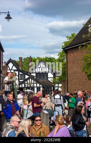 Fêtards et festivaliers appréciant le soleil de printemps sur la place du marché pavée de la ville de Sandbach dans le Cheshire au festival de musique Banque D'Images