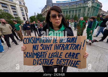 Bucarest, Roumanie. 20 avril 2024 : une femme tient une pancarte qui dit : «les consommateurs de drogue ne sont pas des criminels! Changer les lois qui détruisent les destins" avant un flash mob d'une minute à 16h20, sur la place de l'Université à Bucarest, contre les lois votées par le Parlement roumain et promulguées par le Président, par lequel les toxicomanes seront envoyés en prison, sans possibilité de commutation de la peine, et sera surveillé pendant 10 ans après la libération. Crédit : Lucian Alecu/Alamy Live News Banque D'Images