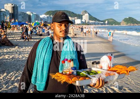 Un vendeur de nourriture sur la plage de Copacabana, Rio de Janeiro, Brésil. Banque D'Images