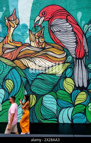 Touristes / visiteurs passent par Une fresque colorée à la première station de téléphérique de Sugarloaf Mountain, Rio de Janeiro, Brésil. Banque D'Images