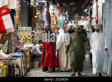 Muscat, Oman - 13 février 2023 : les hommes arabes portant le traditionnel thawb marchent à travers le traditionnel souk de Mutrah, ou bazar, à Mascate dans la capitale d'Oman Banque D'Images