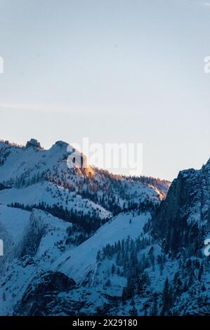 Tôt le soleil attrape les sommets enneigés des sommets de la Sierra nevada dans le parc national de Yosemite, autour du lever du soleil un matin d'hiver tôt. Banque D'Images