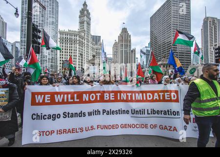 Chicago, États-Unis, 20 avril 2024, les manifestants pro-Palestine tiennent une bannière déclarant que Chicago se tient aux côtés de la Palestine alors qu'ils défilent dans les rues du centre-ville de Chicago pour protester contre l'occupation israélienne de Gaza, pour Joe Biden de mettre fin au financement américain d'Israël, et appeler à un cessez-le-feu, Credit : David Jank/Alamy Live News Banque D'Images