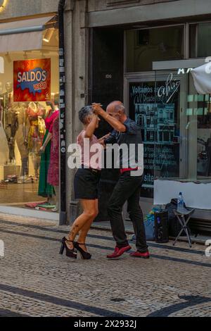 Un couple d'âge mûr amoureux, dansant main dans la main avec beaucoup de style dans une rue pavée de Lisbonne, très heureux et uni. Banque D'Images