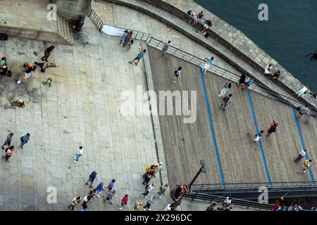 Vue aérienne zénith des gens, des touristes et des familles vus d'en haut marcher et prendre des photos le long de la promenade de Porto du pont Dom Luis Ribeira Banque D'Images