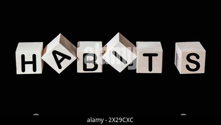 Le mot habits écrit sur des cubes en bois et fond noir Banque D'Images