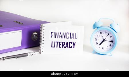 Littératie financière écrite sur un bloc-notes et un fond blanc. Concept d'éducation. Banque D'Images