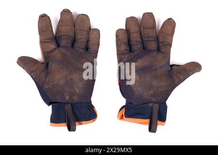 Gants de jardinage sales portés isolés sur un fond blanc. Paire de gants de sécurité boueuse déchiré et bien utilisé. Banque D'Images