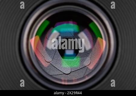 Lames d'ouverture d'un objectif photographique avec reflets de couleur en gros plan. Banque D'Images
